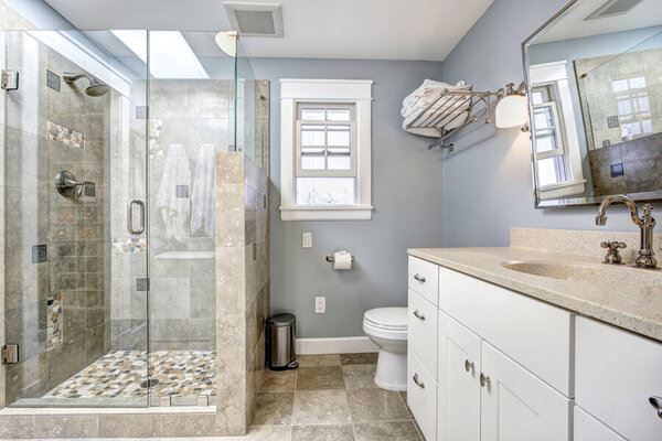 Newly remodeled bathroom with grey walls and stone shower